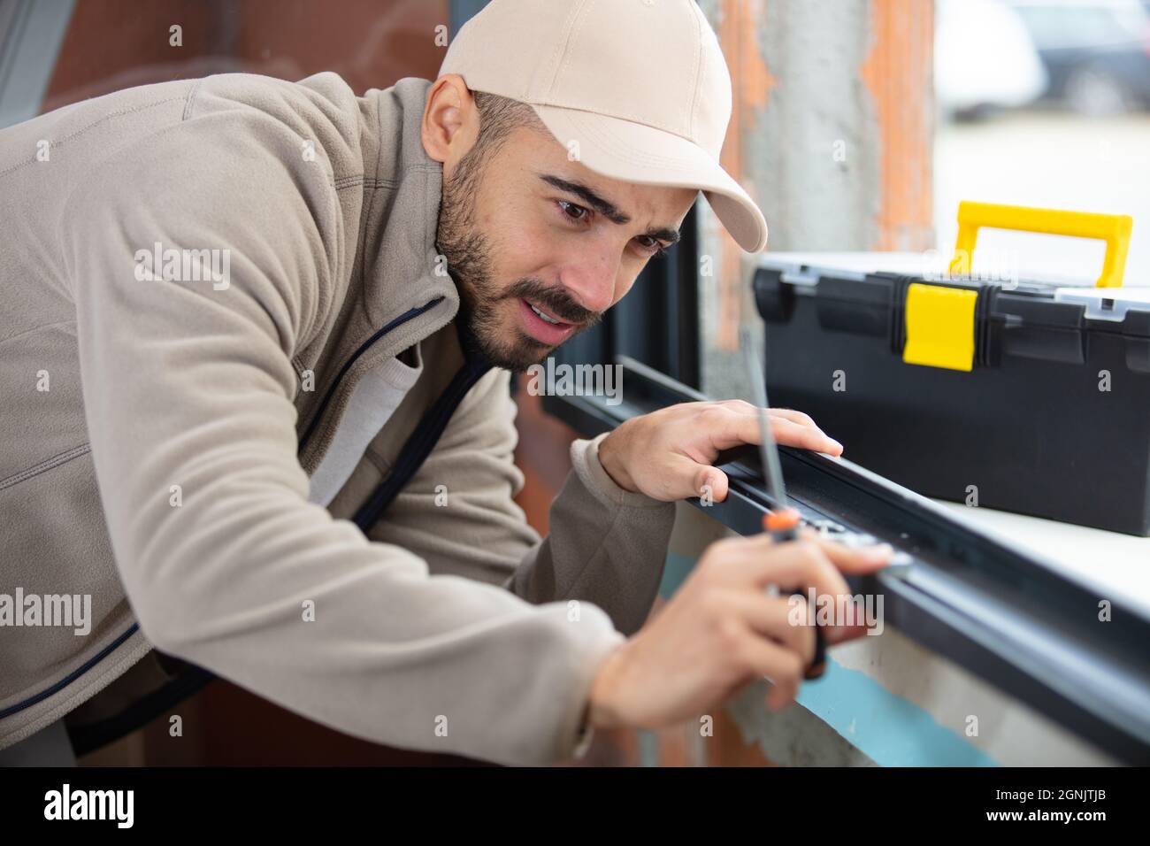 male worker installing sill on external pvc window frame Stock Photo