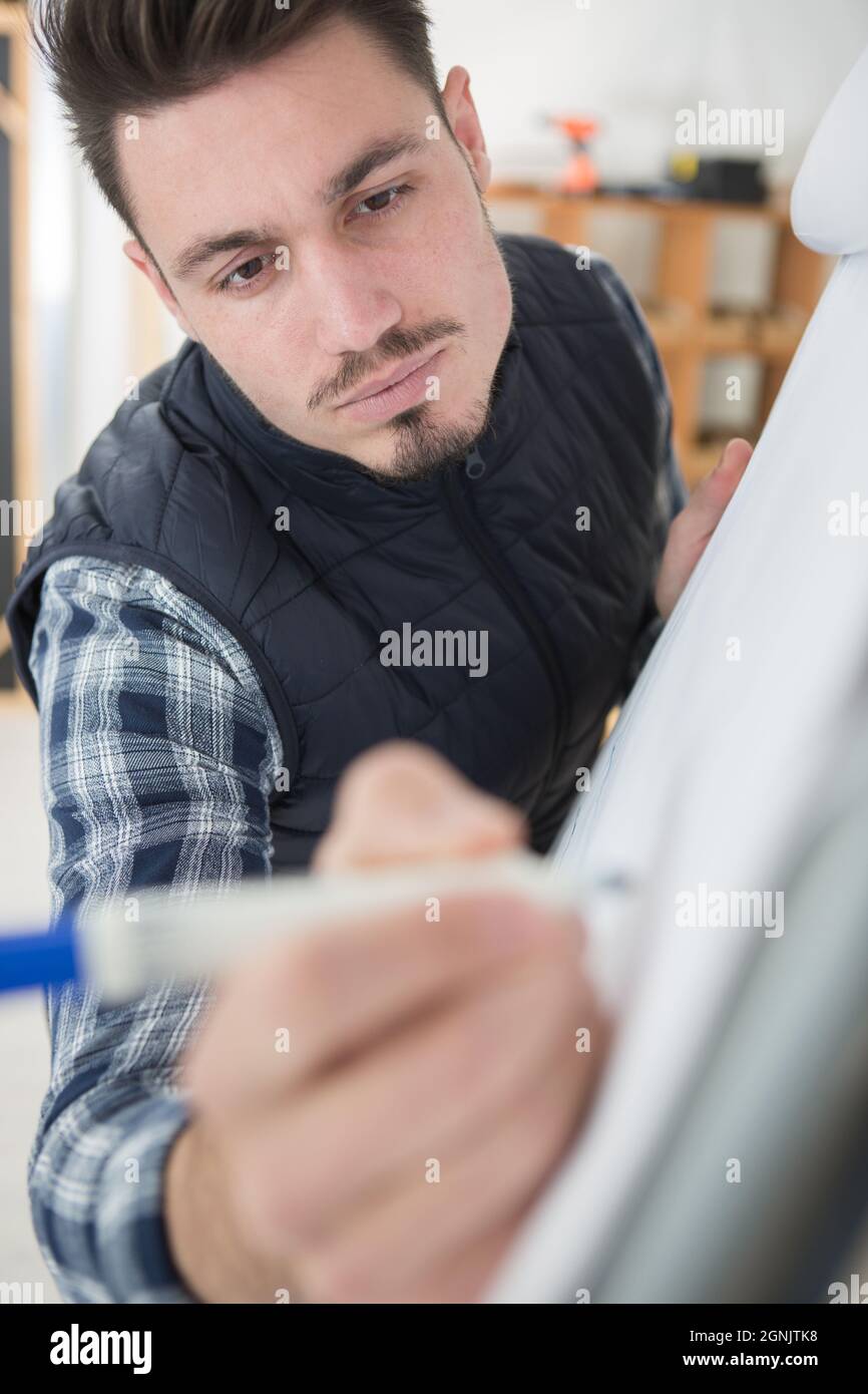 man writes on a white board Stock Photo