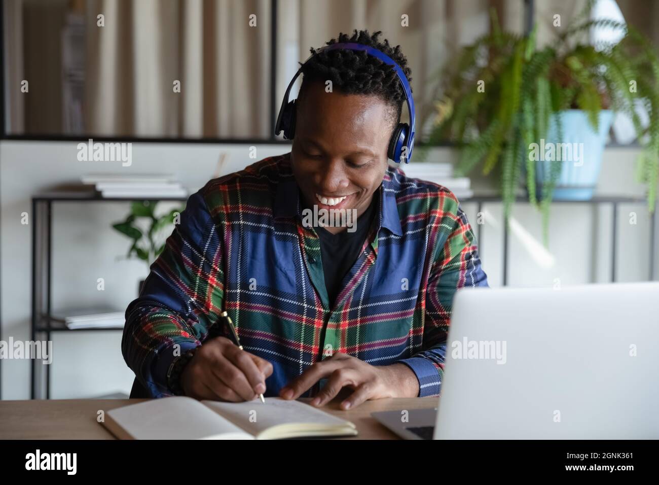 Happy student guy in wireless earphones taking distance learning course Stock Photo