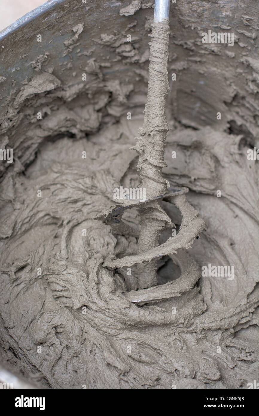 Mixing a plaster solution by an electric drill. Adhesive mixing. Home