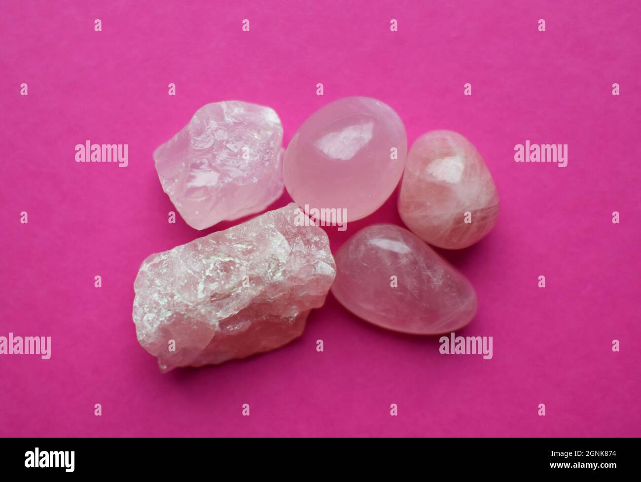 Crystals of rose quartz on a bright pink background. Beautiful semi-precious stones Stock Photo