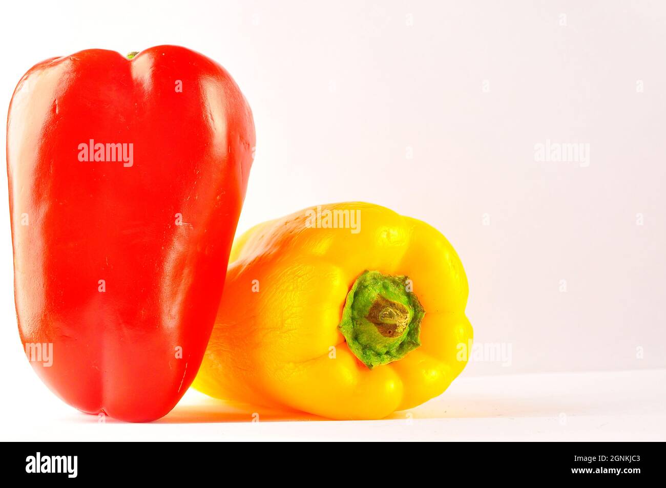 Red and yellow pepper on white background Stock Photo - Alamy