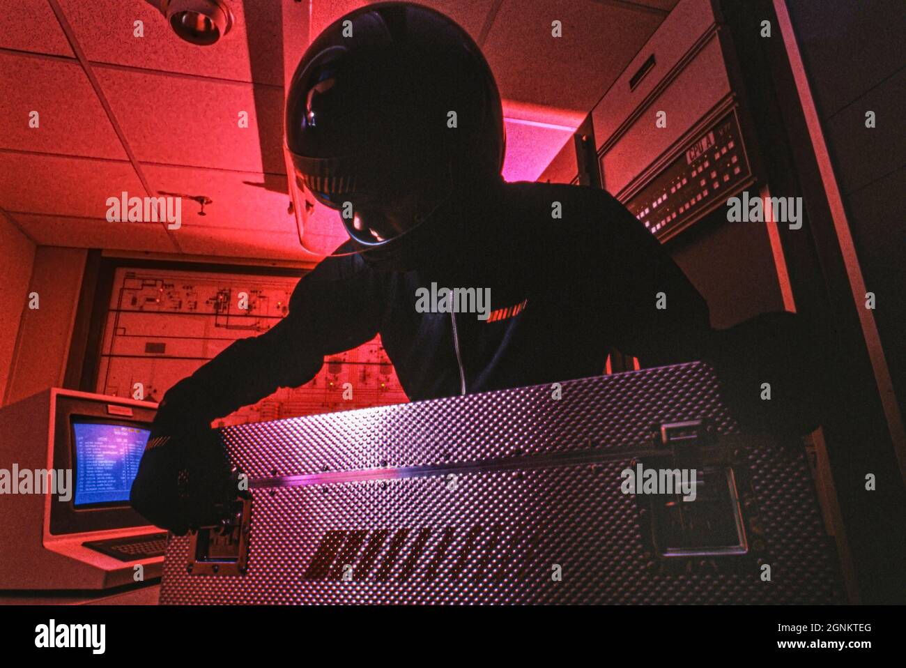 1980s Technology retro vintage Man in black in industrial computer room opening a large aluminium case. Concept concepts covert historic  industrial secrets sensitive commercial information security Stock Photo