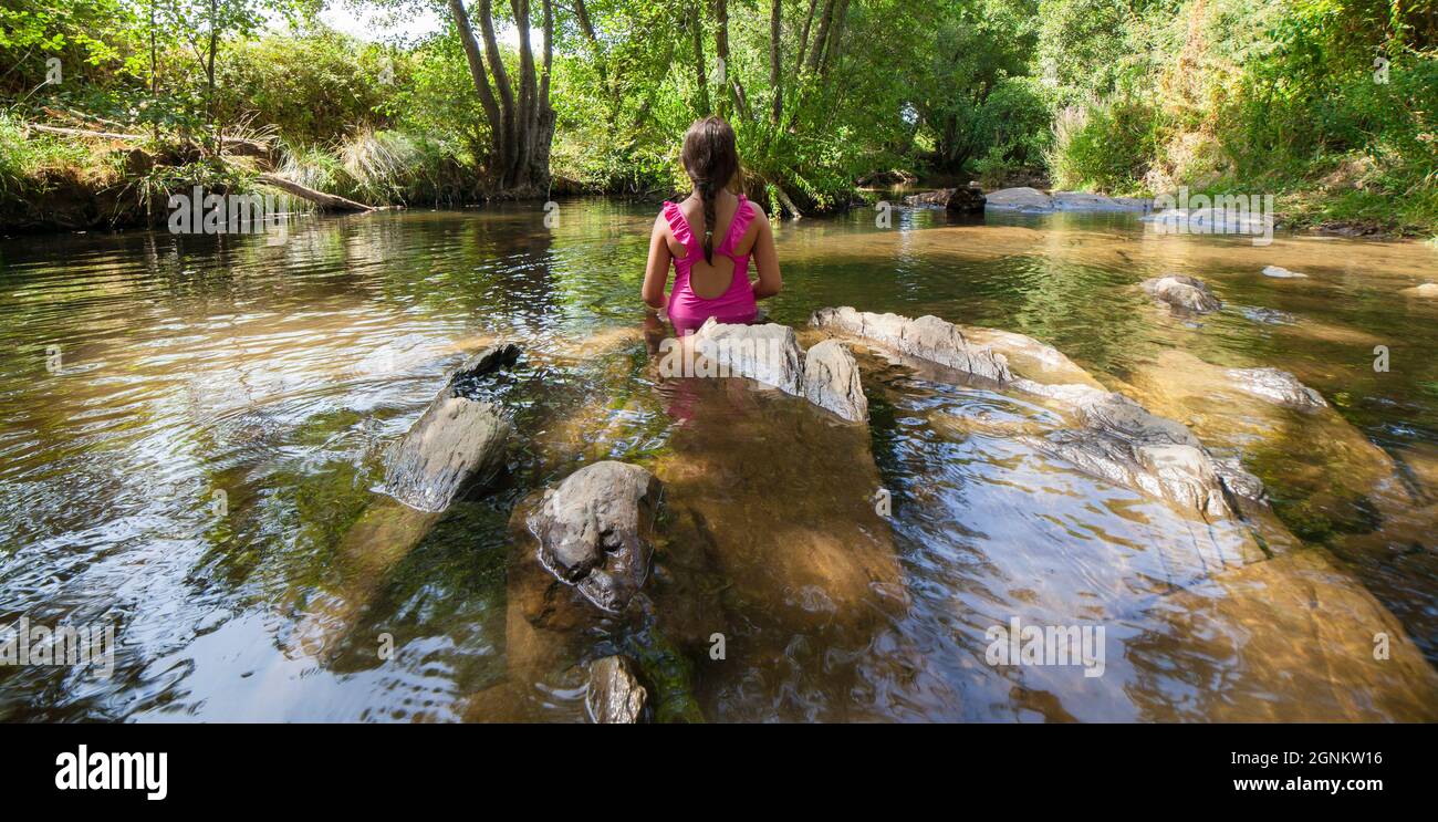Child girl discovering Gevora river, La Codosera, Badajoz, Extremadura, Spain. Idyllic location of crystal clear waters and riverside forests Stock Photo