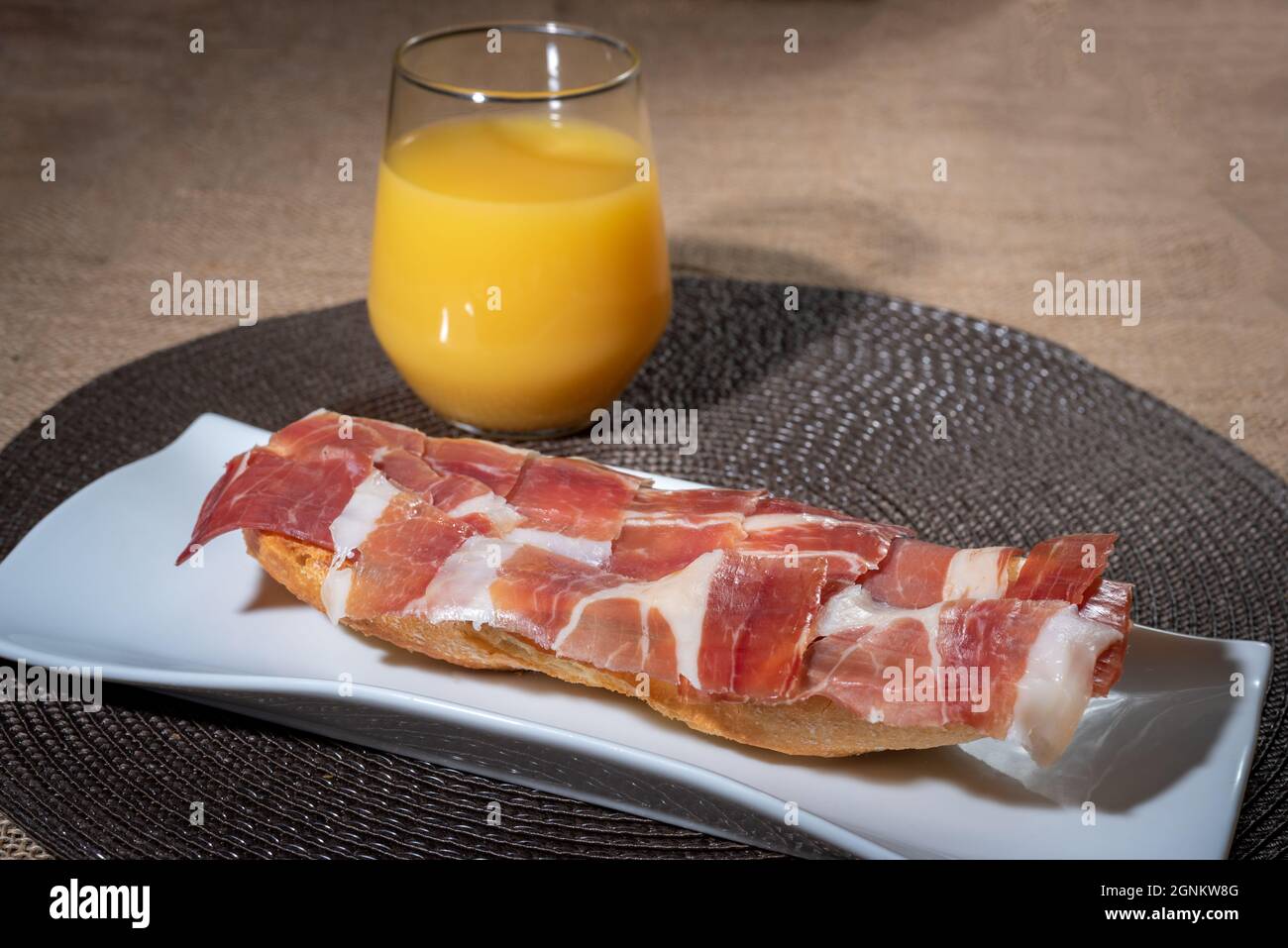 Breakfast Consisting Of An Orange Juice And A Serrano Ham Toast With