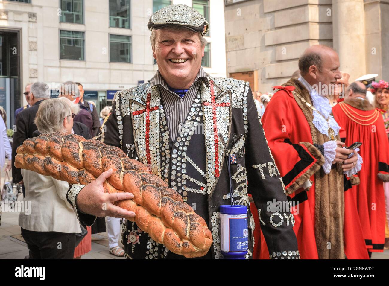 St Mary-Le-Bow, London, UK. 26th Sep, 2021. A Pearly King with his Prince and Princess brings a loaf of bread offering to the Costermonger's Harvest service. Pearly Kings and Queens celebrate their annual harvest festival with the Costermonger´s Harvest Service at St Mary-Le-Bow church. As the usual celebrations in Guildhall Yard had to be cancelled, the Pearlies meet and greet friends and the public outside the church before and after service his year. Credit: Imageplotter/Alamy Live News Stock Photo