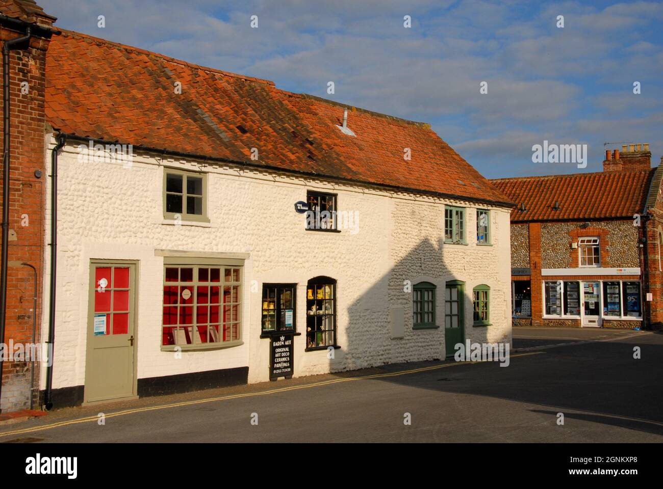 Building in the market town of Holt, Norfolk, England with flint wall painted over, and tiled roof, 2013 Stock Photo