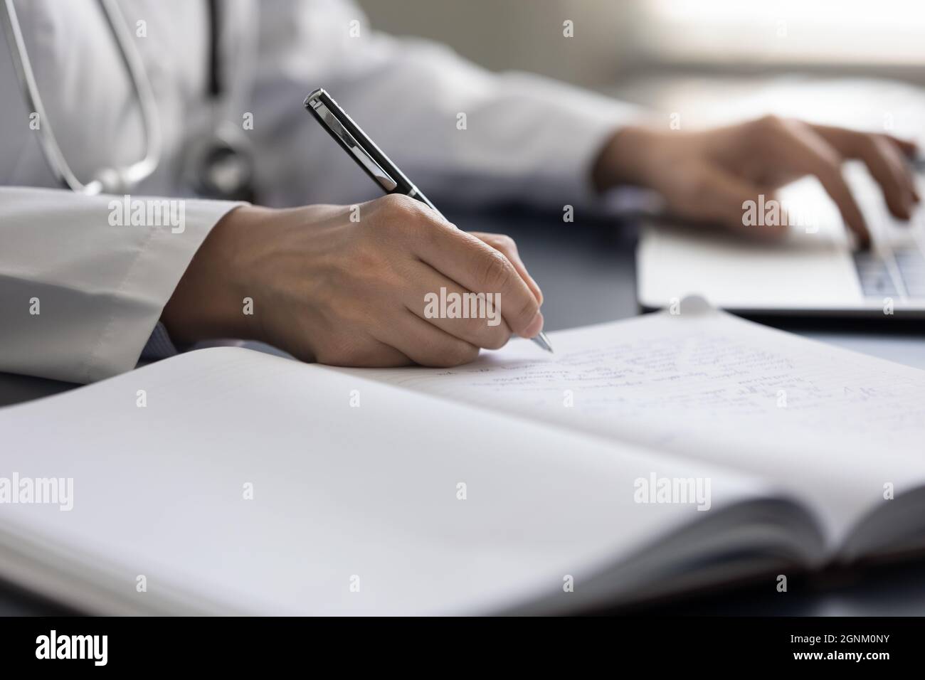 Female GP doctor writing medical records in workbook Stock Photo Alamy
