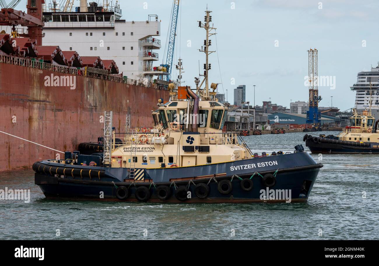 Southampton, England, UK. 2021. An ocean going tug manoeuvres a bulk carrier ship onto her berth in the port of Southampton. Stock Photo