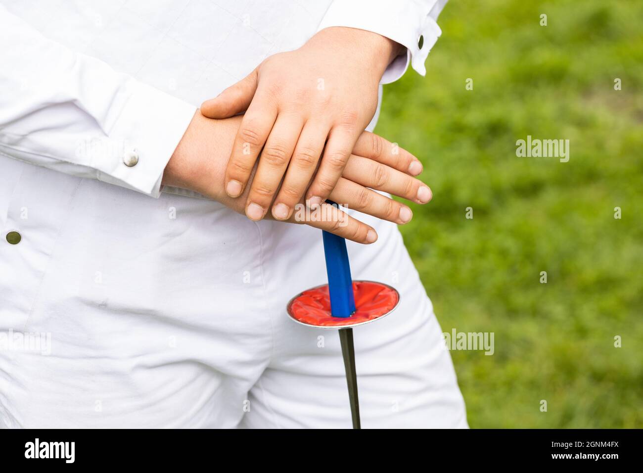 A swordsman dressed in white and holding a sword Stock Photo