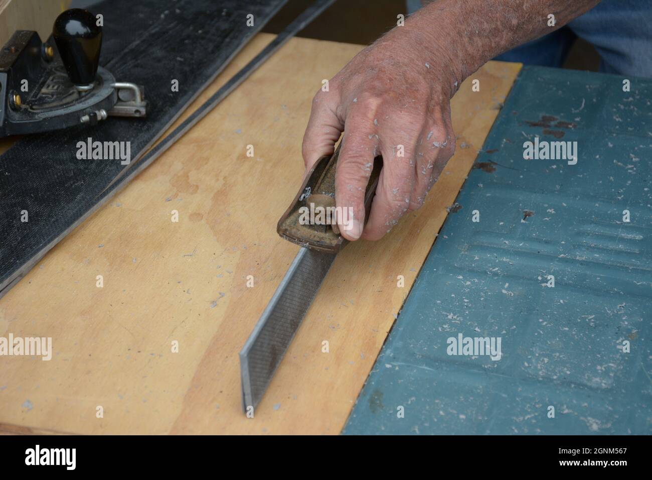 Do It Yourself senior men and Home owners cutting an preparing laminate flooring for their home using saws, planes and other tools which are dangerous Stock Photo