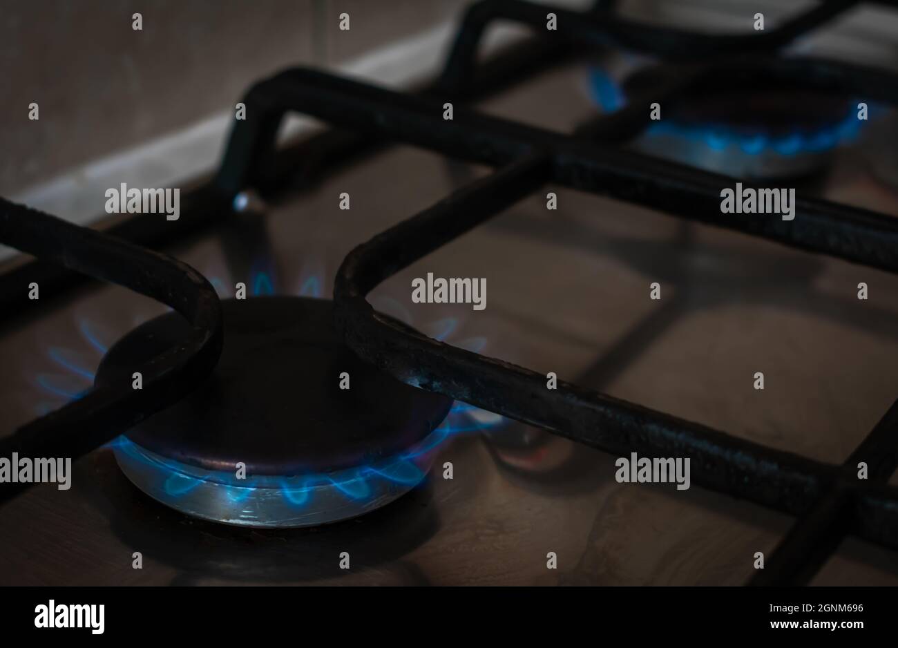 A gas hob in a kitchen with the blue flames of gas fire on Stock Photo