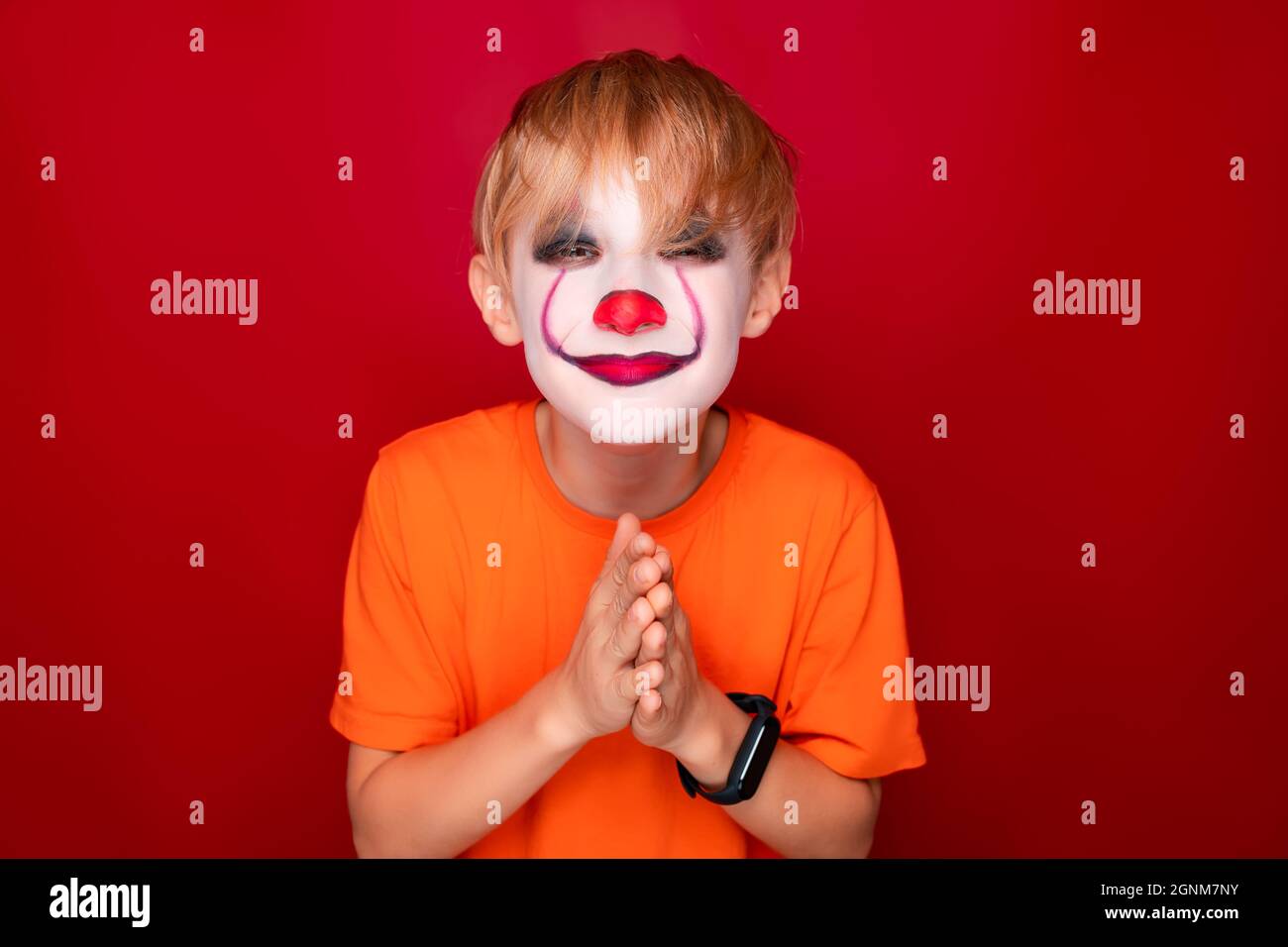 child with halloween makeup screwed up his eyes and looks at the camera ...