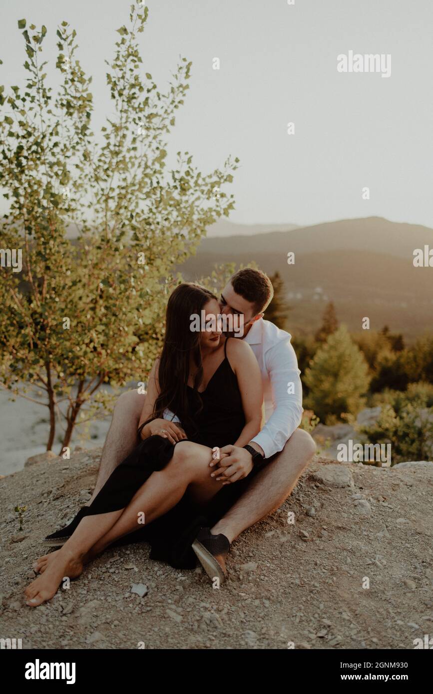 A young romantic couple sitting and posing in a park Stock Photo ...