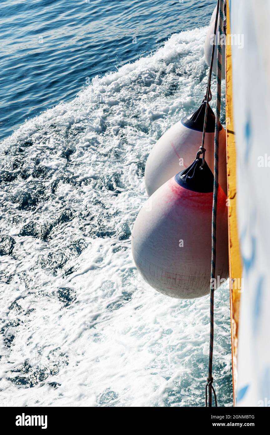 fenders to moor ships in a harbor. Boat fenders between birth and motor