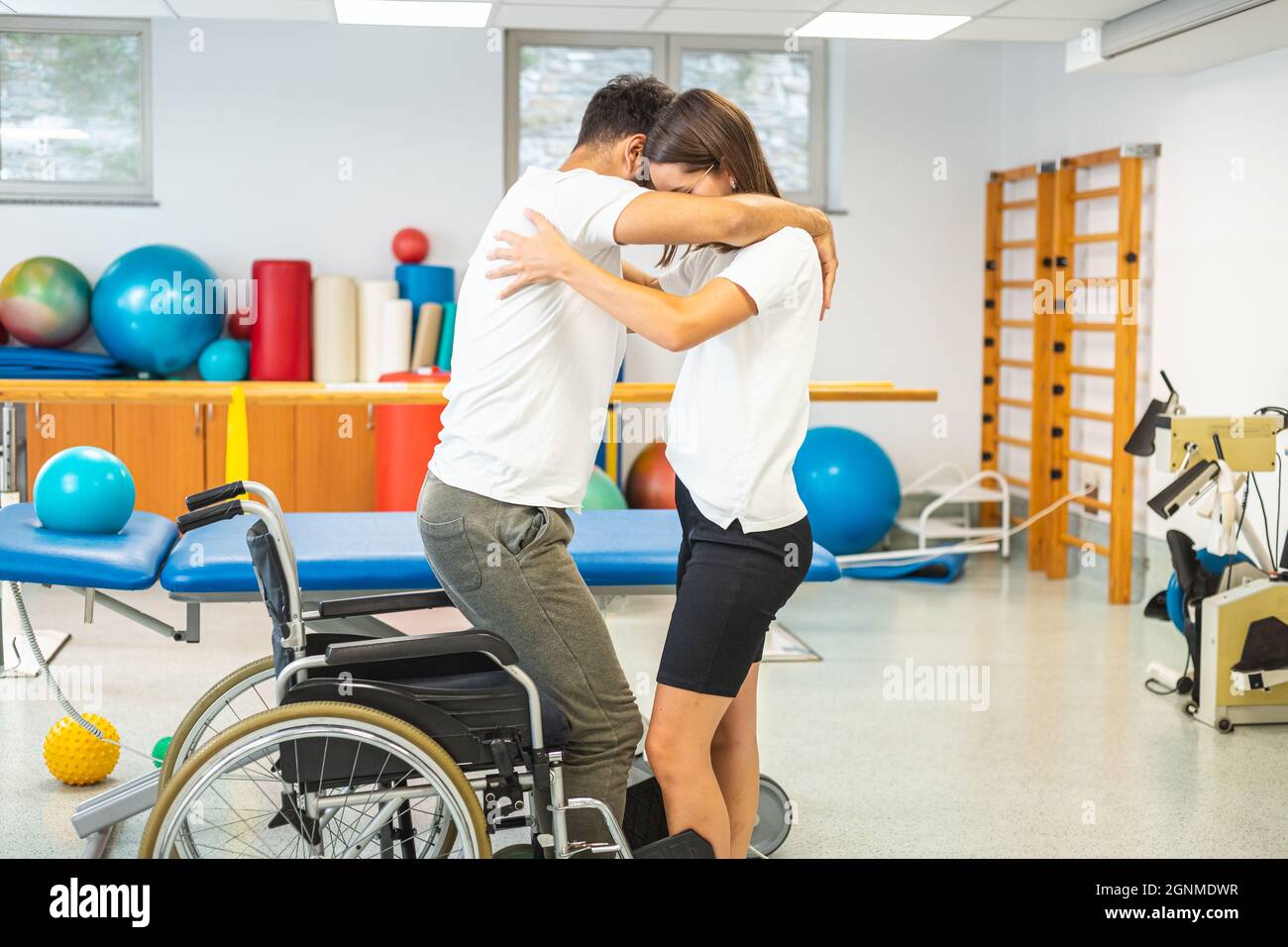 Disabled patient and female physiotherapist, exercise standing up and