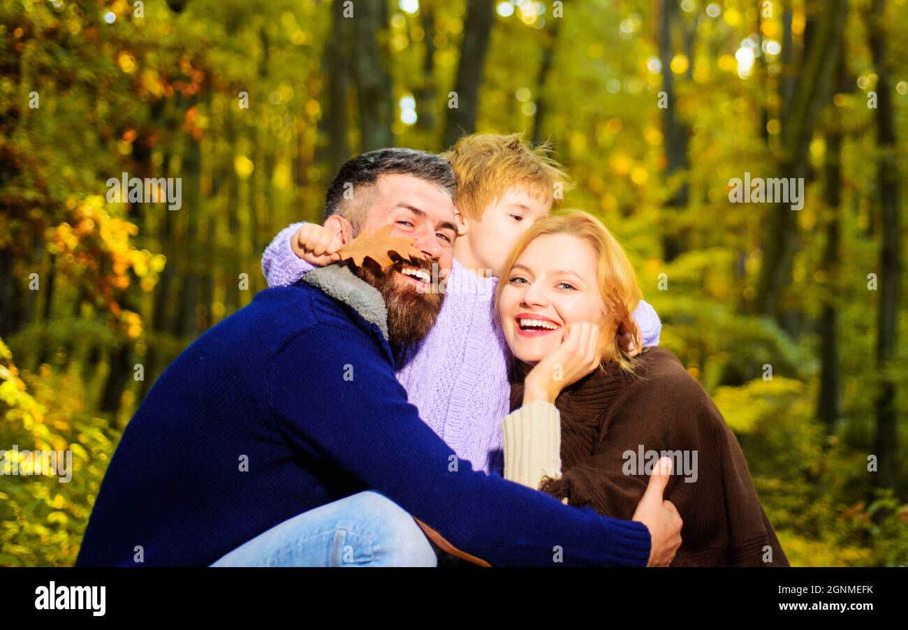 Happy family. Mother, father and little son together in park. Autumn nature. Smiling Autumn couple. Stock Photo