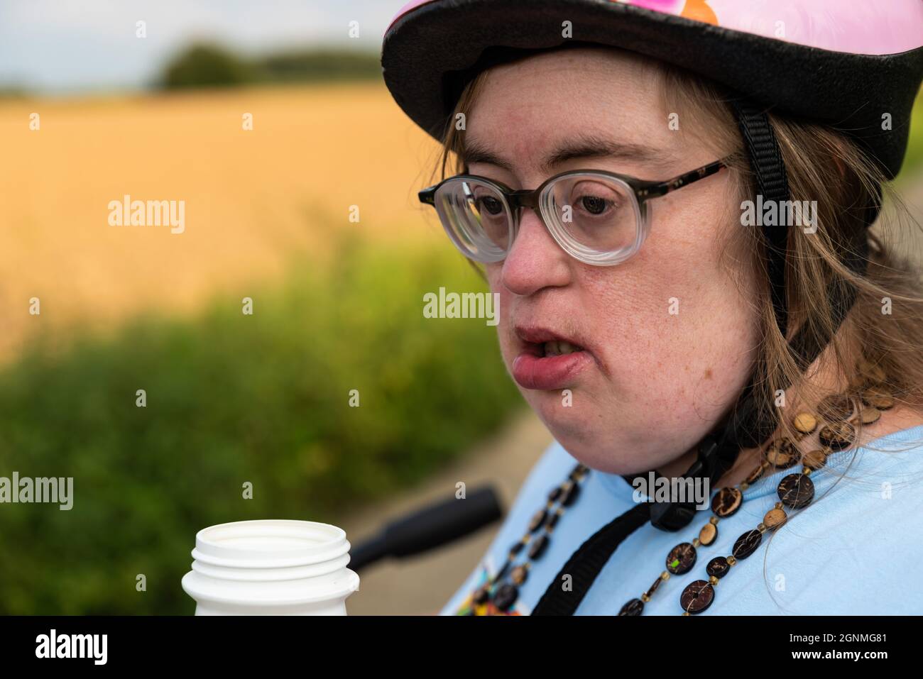 Portrait of a 39 year old woman with the Down Syndrome, wearing glasses