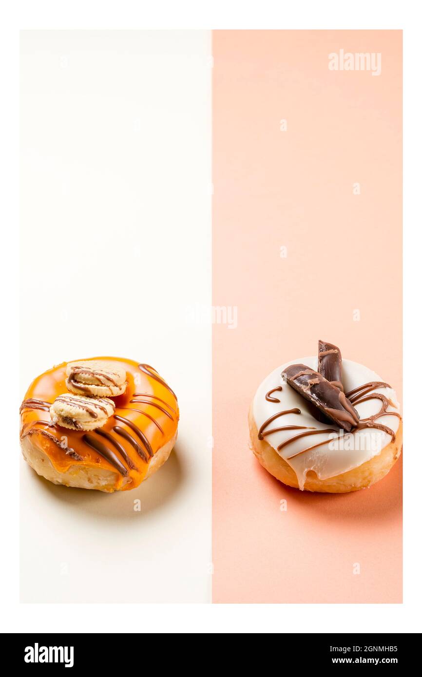 Photograph of two donuts decorated with cookies and drawn with chocolate.The photo is taken in portrait format and has a white frame around it. Stock Photo