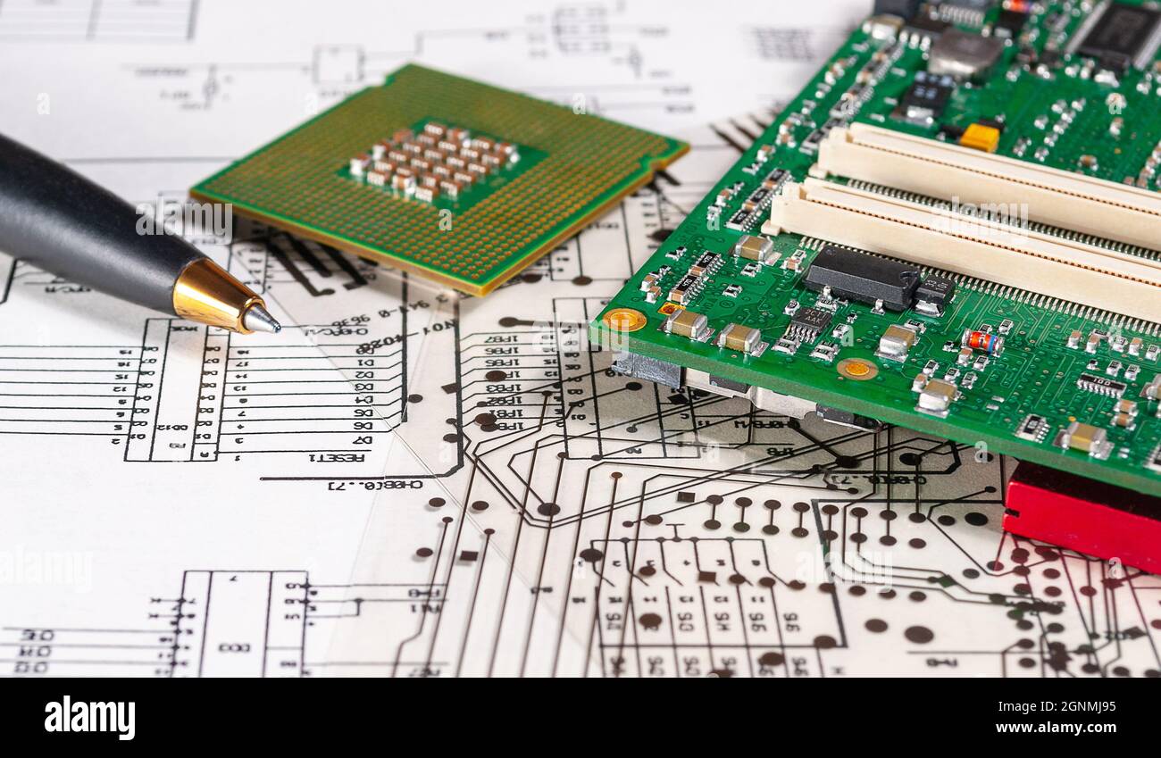 Electronic board, pen, processor and radio components lie on the background of an schematic circuit diagramm and a photomask for the manufacture of pr Stock Photo