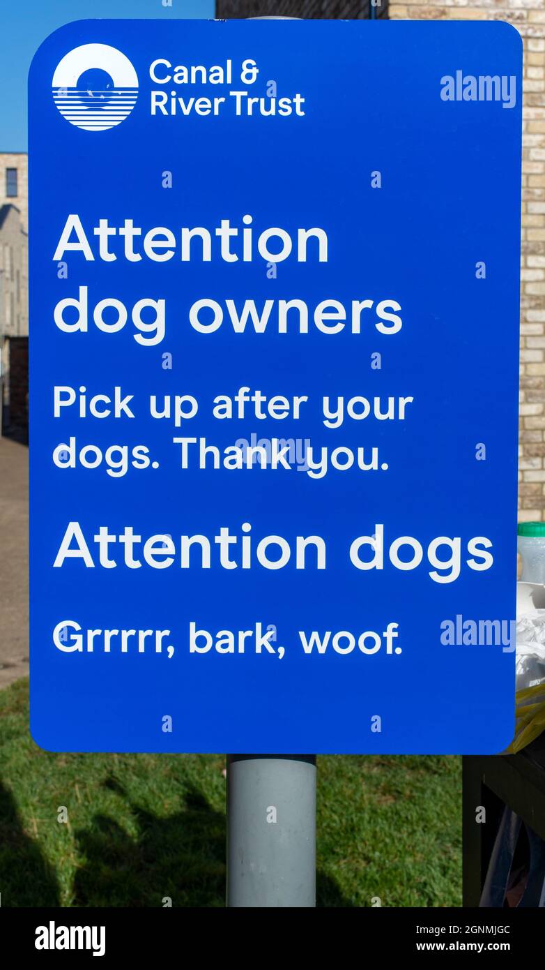 Sign asking dog owners to pick up after their dogs, with an amusing comment for dogs.  By the Ashton Canal, Ancoats, Manchester, England, UK Stock Photo