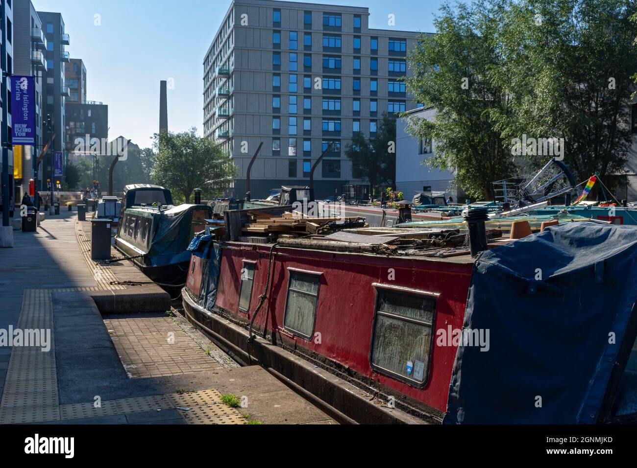 Narrowboats at Cotton Field Park marina, with the One Vesta Street apartment block behind, New Islington, Ancoats, Manchester, England, UK Stock Photo