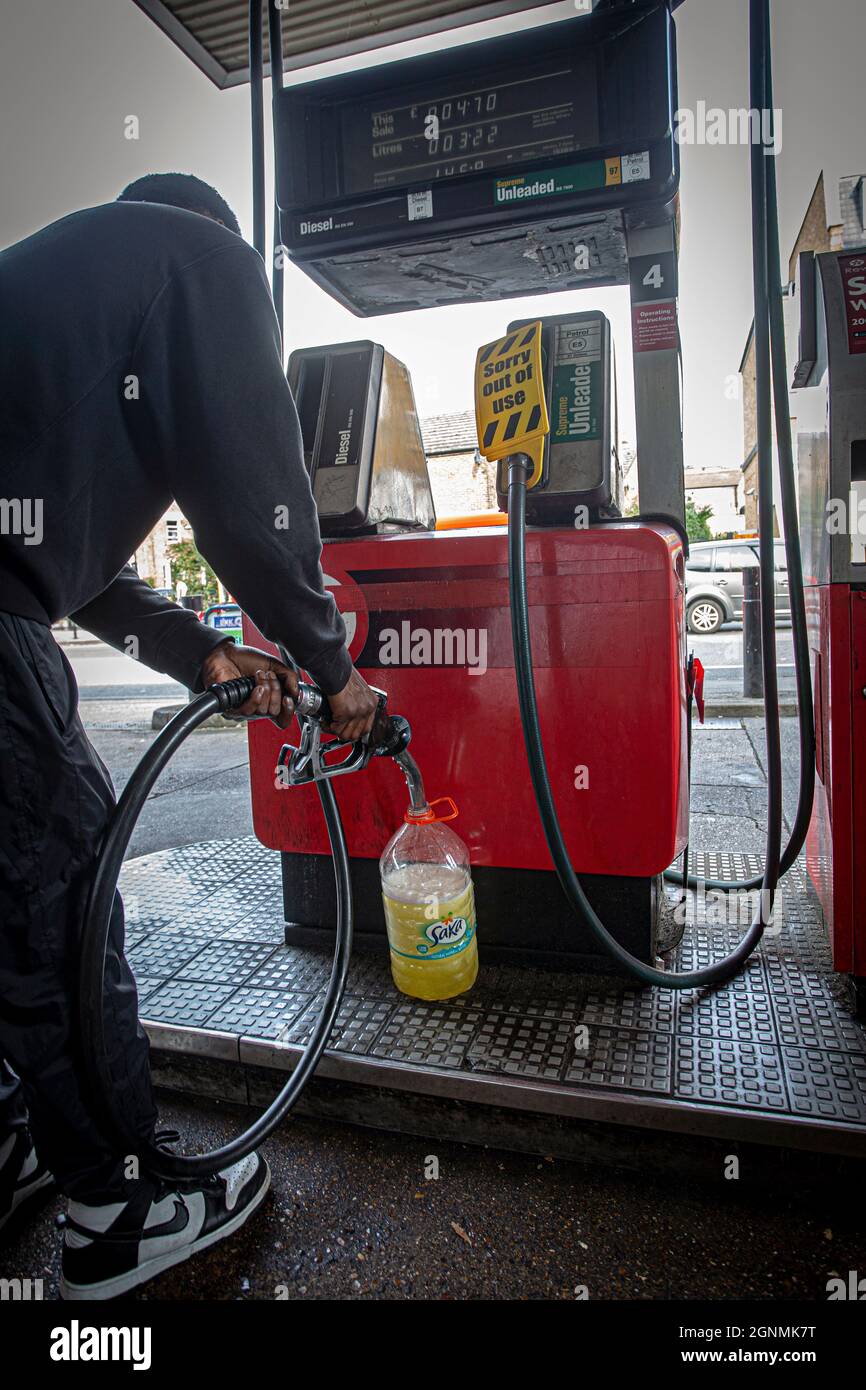 Petrol driver shortage , Desperate motorist fill plastic bottle  with fuel in London , United Kingdom Stock Photo