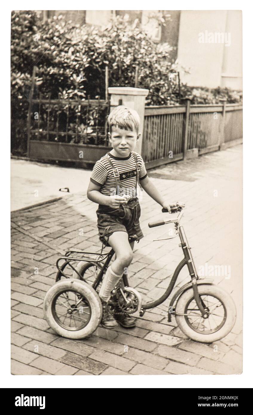 Vintage photo of cute boy with bicycle. Old picture with original film grain, blur and scratches Stock Photo