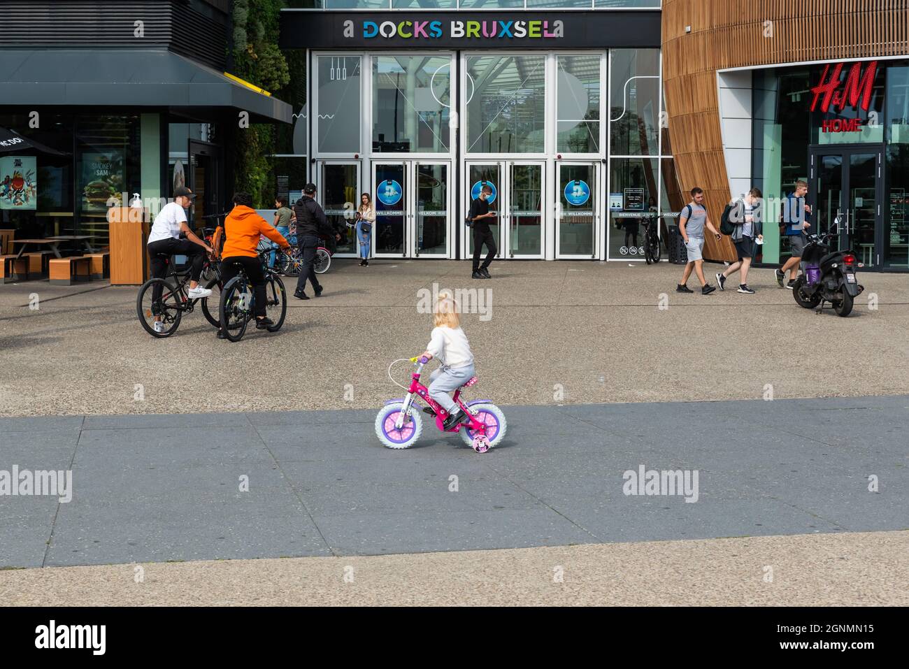 Laeken, Brussels Capital Region, Belgium, Brussels - 09 24 2021: Toddler girl and teenagers at the entrance of the Docks Bruxsel entertainment site Stock Photo