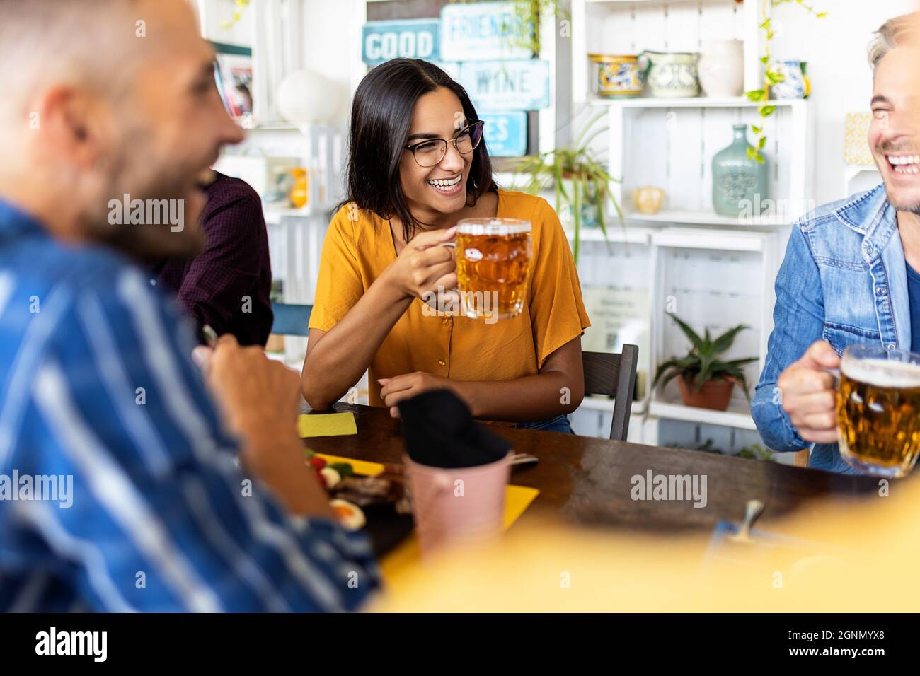 Happy people celebrating and drinking beer together on rooftop restaurant  Stock Photo