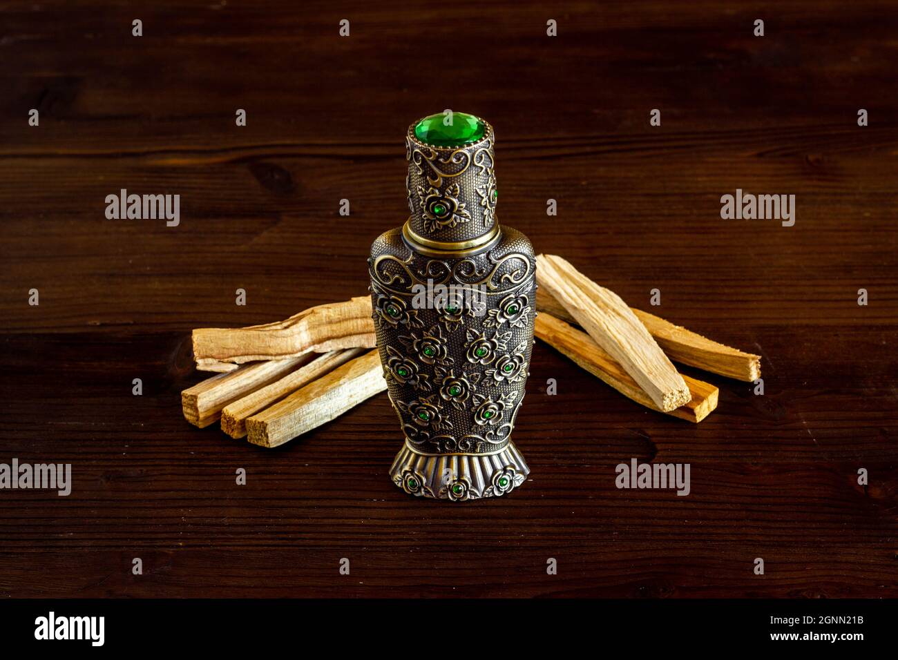 Agar wood tree oil perfume in silver bottle with sticks of tree