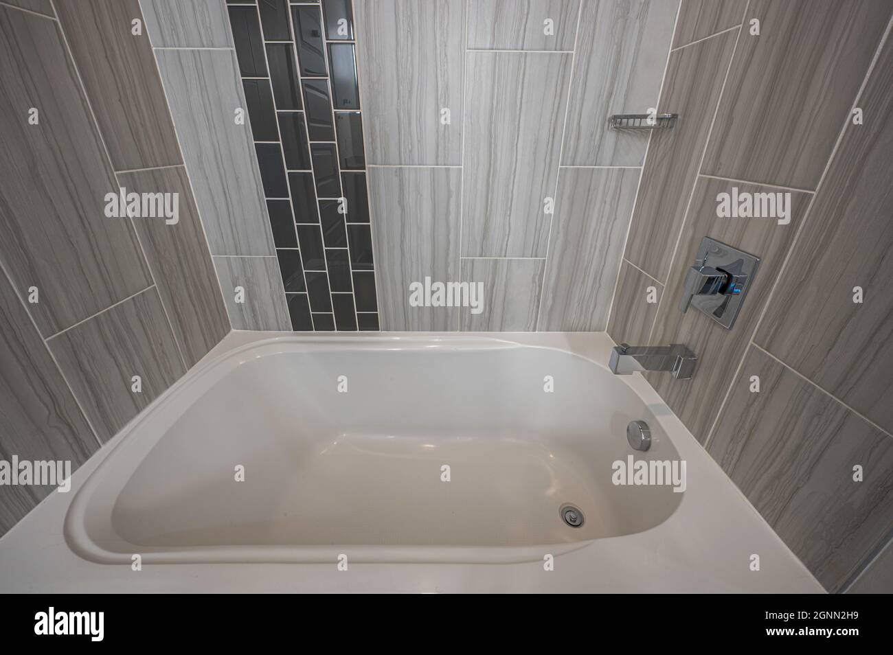Modern bathtub with black and grey tiles Stock Photo Alamy