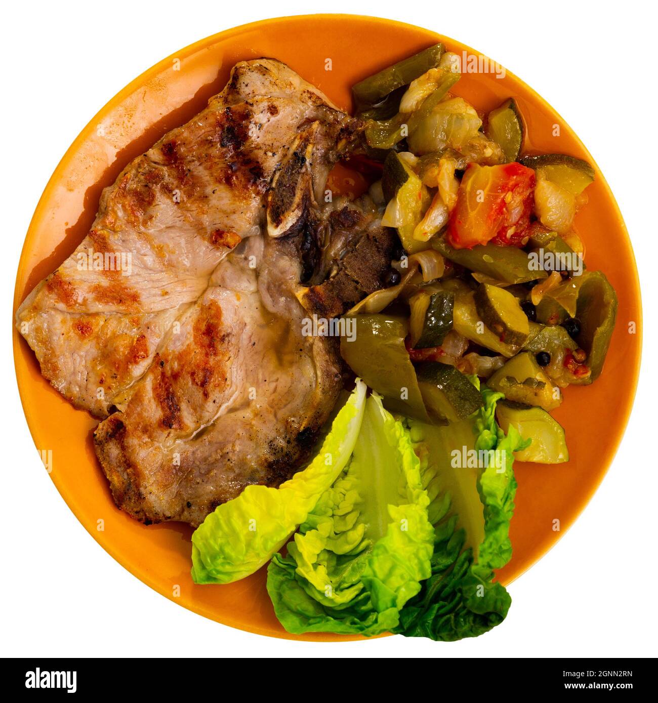 Juicy roast pork on a plate with stewed vegetables Stock Photo
