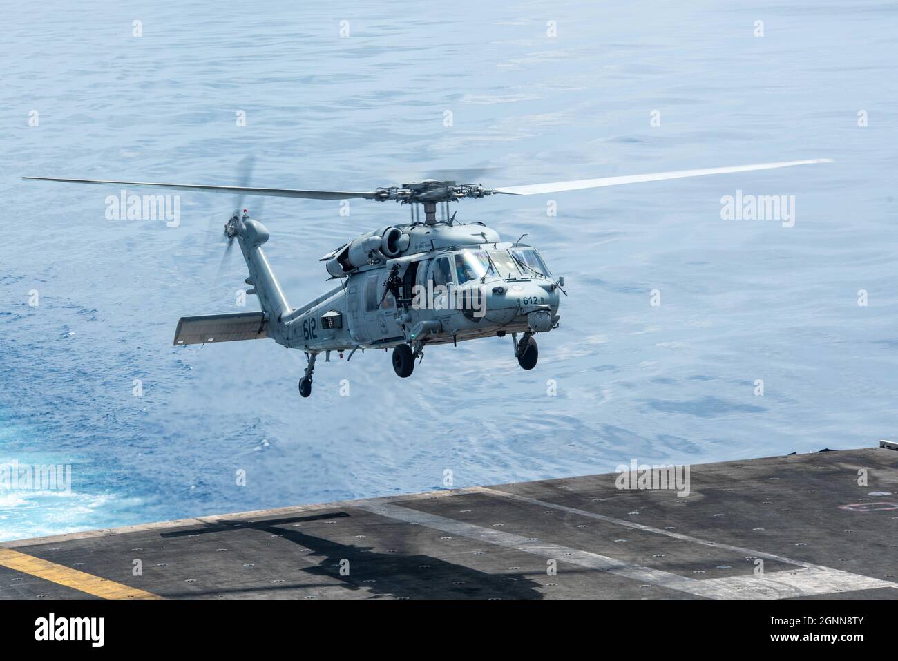 210925-N-CW176-1031 SOUTH CHINA SEA (Sept. 25, 2021) – An MH-60S Sea Hawk, attached to the Golden Falcons of Helicopter Sea Combat Squadron (HSC) 12, launches from the flight deck of the U.S. Navy’s only forward-deployed aircraft carrier USS Ronald Reagan (CVN 76). Ronald Reagan, the flagship of Carrier Strike Group 5, provides a combat-ready force that protects and defends the United States, and supports alliances, partnerships and collective maritime interests in the Indo-Pacific region. (U.S. Navy photo by Mass Communication Specialist Seaman Matthew Mitchell) Stock Photo