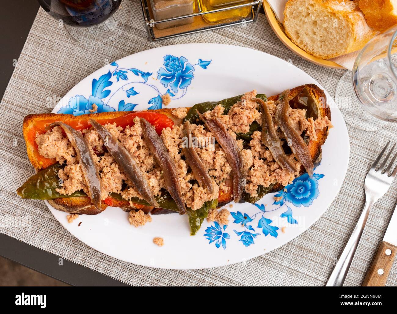 Toasted bread with chopped tuna, anchovies and baked bell pepper Stock Photo Alamy
