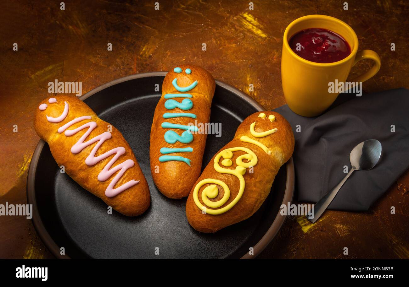 three guaguas de pan on a plate next to a yellow jug with colada morada. Typical food of Ecuador on the day of the dead Stock Photo