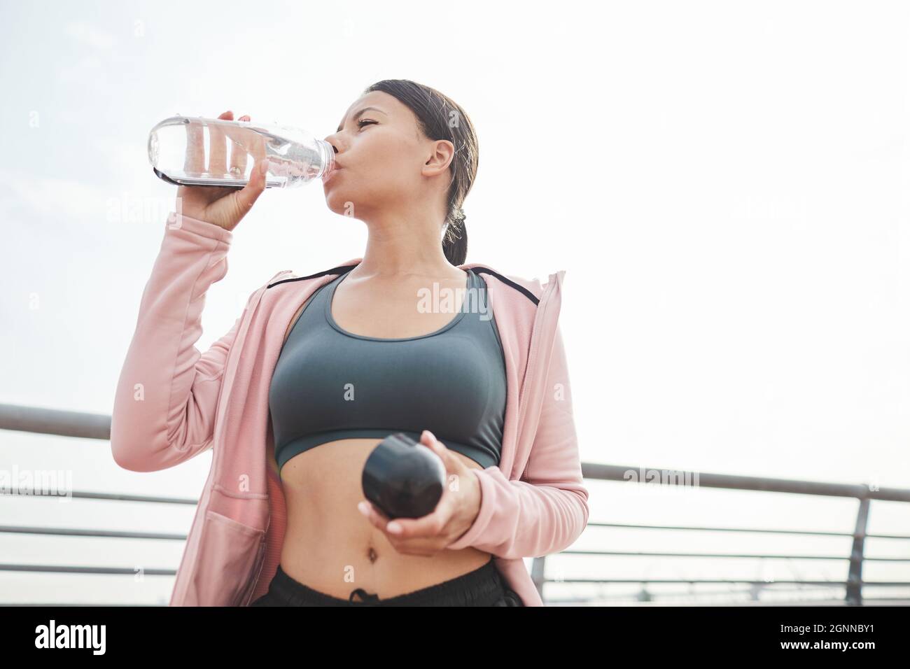 https://c8.alamy.com/comp/2GNNBY1/young-sportive-woman-drinking-water-from-the-bottle-after-sports-training-outdoors-2GNNBY1.jpg