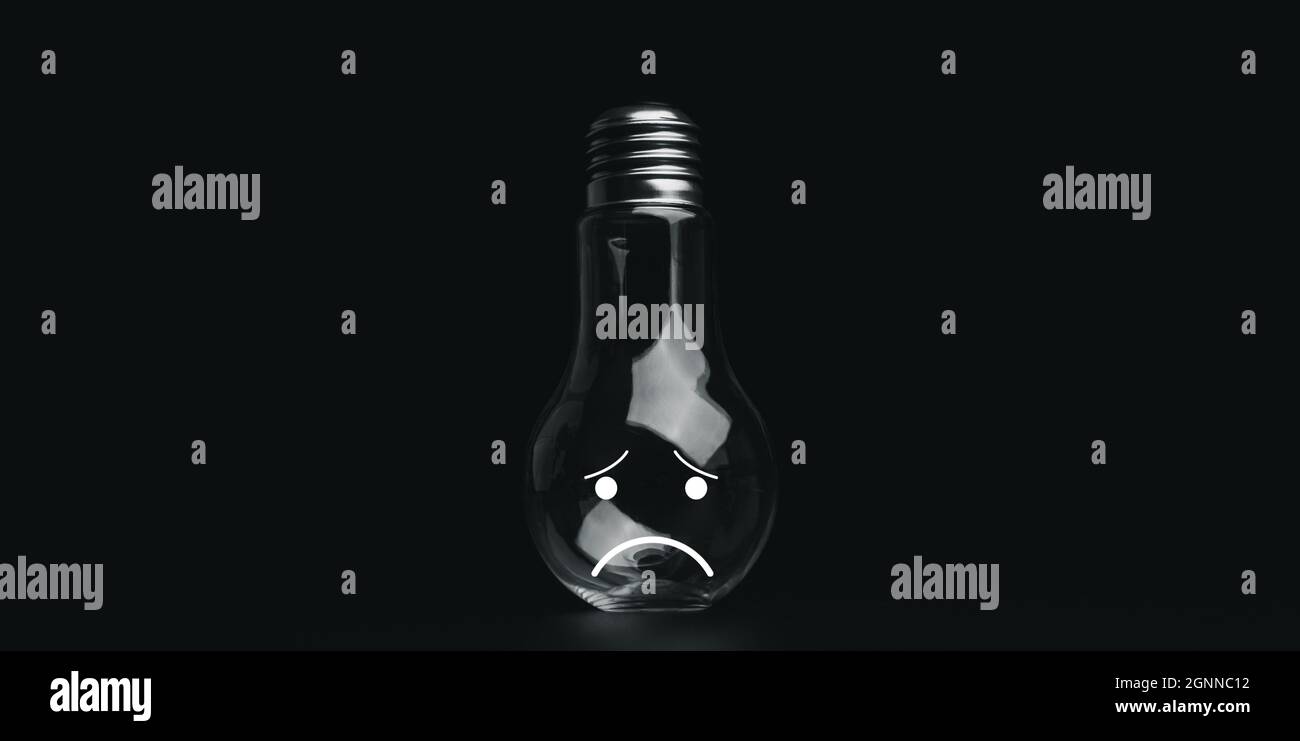 No idea concept. Upside down light bulb with sad face emoticon on dark
