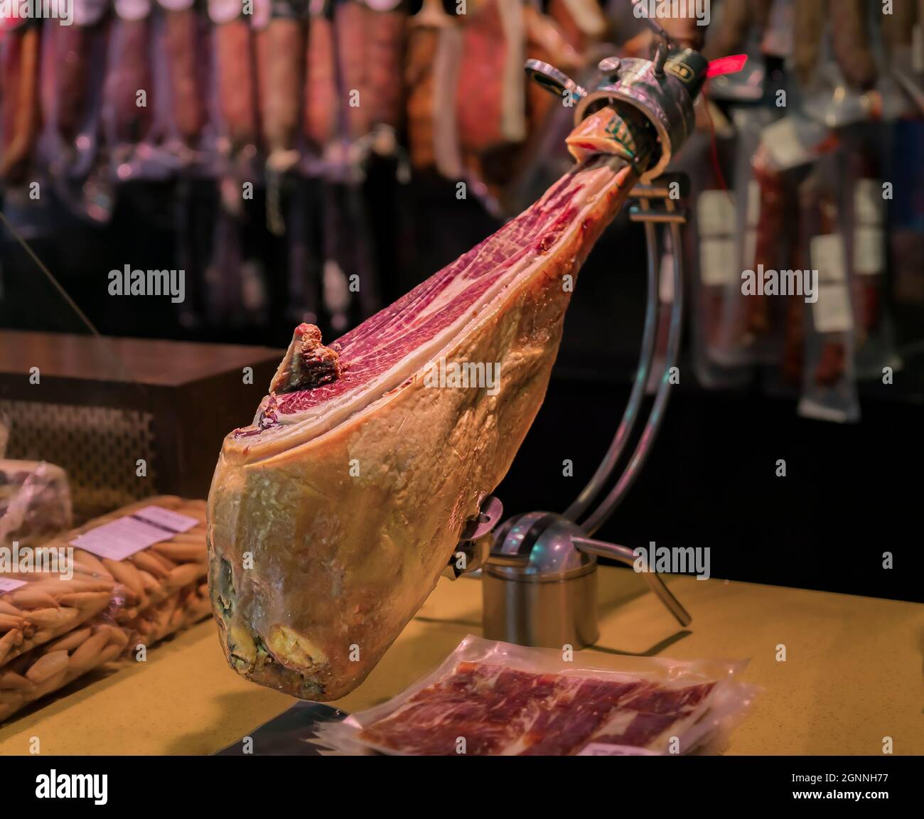 Whole bone-in leg of Spanish serrano iberico ham on a carving stand at a local butcher shop in the old town or Casco Viejo in Pamplona, Spain Stock Photo