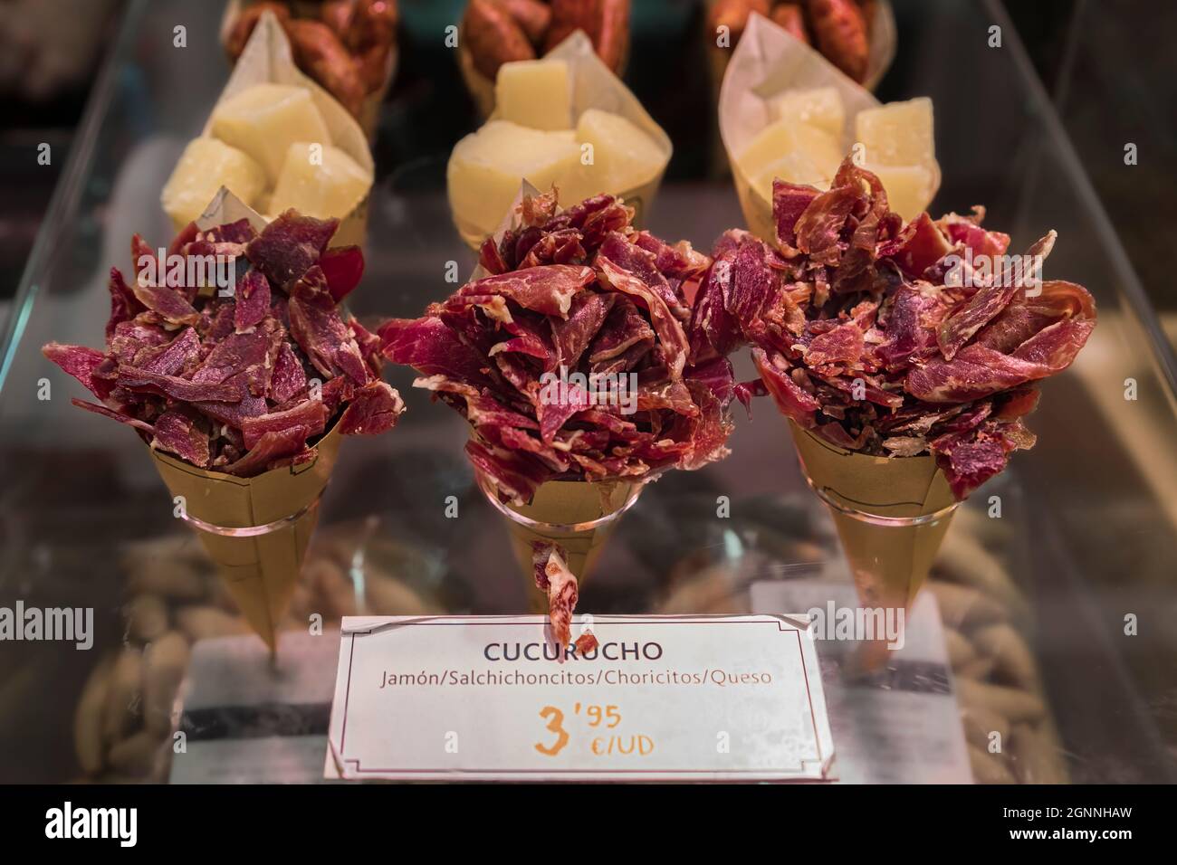 Cones or cucurucho pintxos or tapas with Spanish serrano iberico ham carvings, sausage and cheese pieces at a local butcher shop in Pamplona Spain Stock Photo