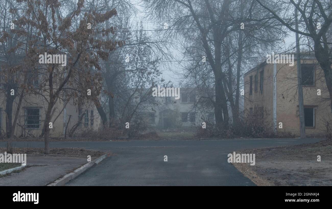 An abandoned street with abandoned two-story houses on a foggy day Stock Photo