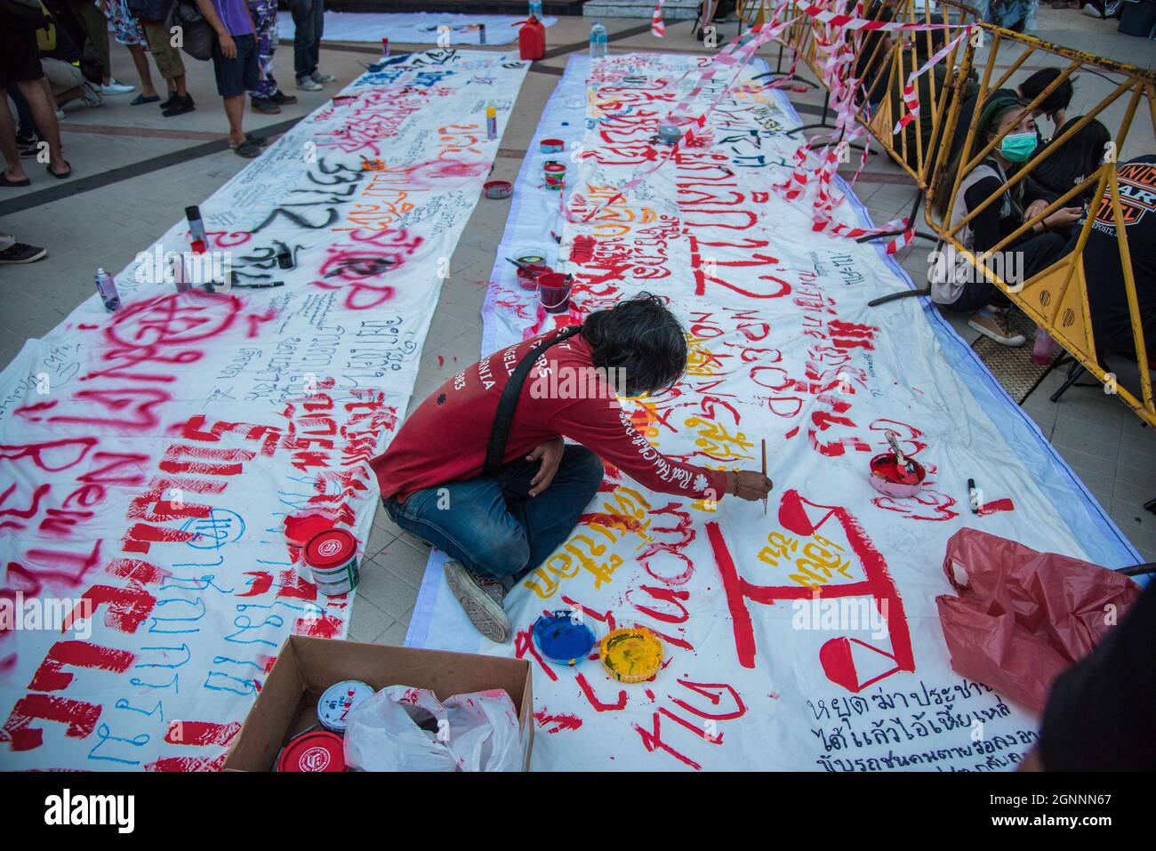 Bangkok, Thailand. 26th Sep, 2021. A protester paints a banner during the demonstration.Pro-democracy protesters gathered at the Bangkok Art and Culture Center (BACC) on September 26, 2021 to mark the 1st anniversary of political movement in Thailand that led by United Front of Thammasat and Demonstration (UFTD) demanding the resignation of Prayut Chan-O-Cha and the monarchy reform. Credit: SOPA Images Limited/Alamy Live News Stock Photo