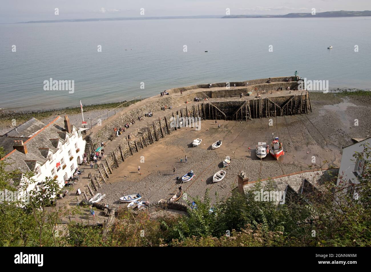 Clovelly harbour at low tide with Red Lion Hotel and two tier wharf with old mooring poles North Devon UK Stock Photo