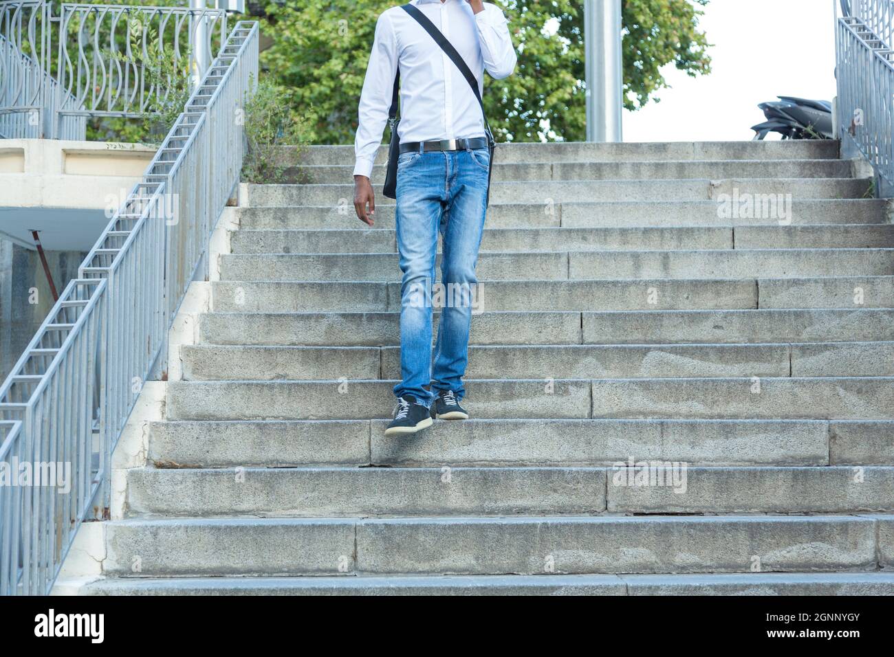 young black business man walking down stairs and talking on the phone Stock Photo