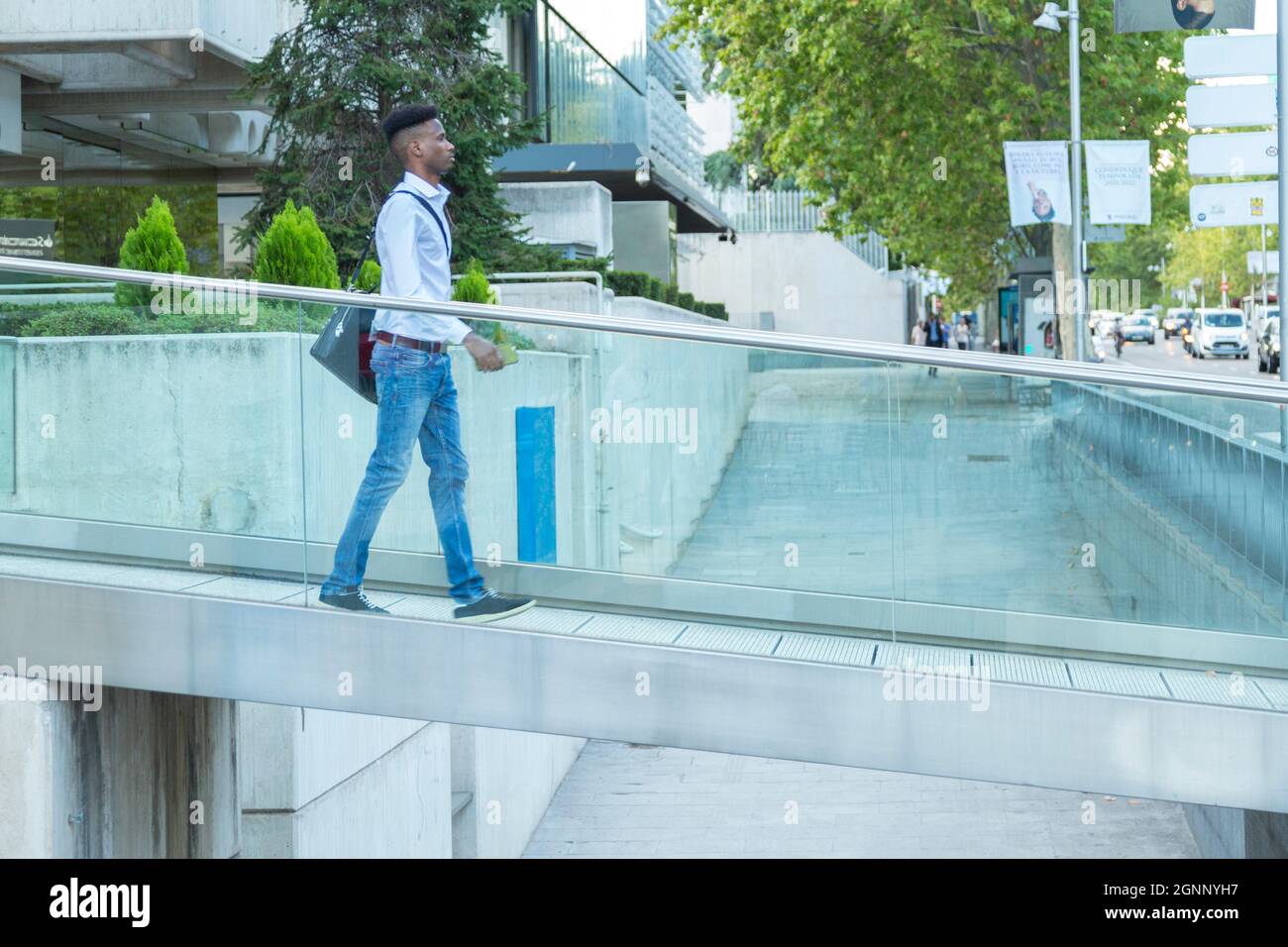 young black business man walking on a glass bridge connected by phone Stock Photo