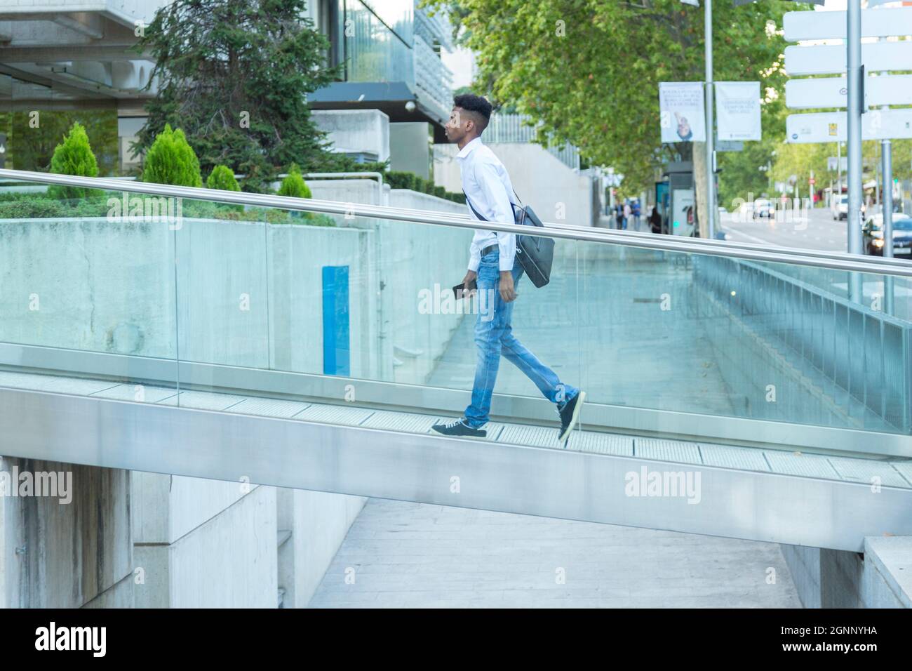 young black business man walking on a glass bridge Stock Photo