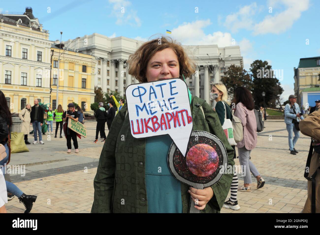 KYIV, UKRAINE - SEPTEMBER 26, 2021 - An environmental activist holds the 'Enough Frying Me Up' placard in Mykhailivska Square during the march urging Stock Photo