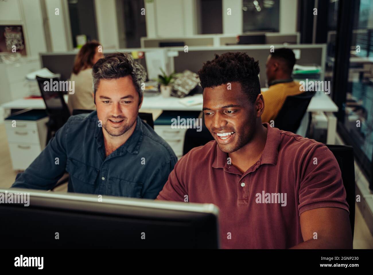 Two mixed race business men working on collaboration project typing on