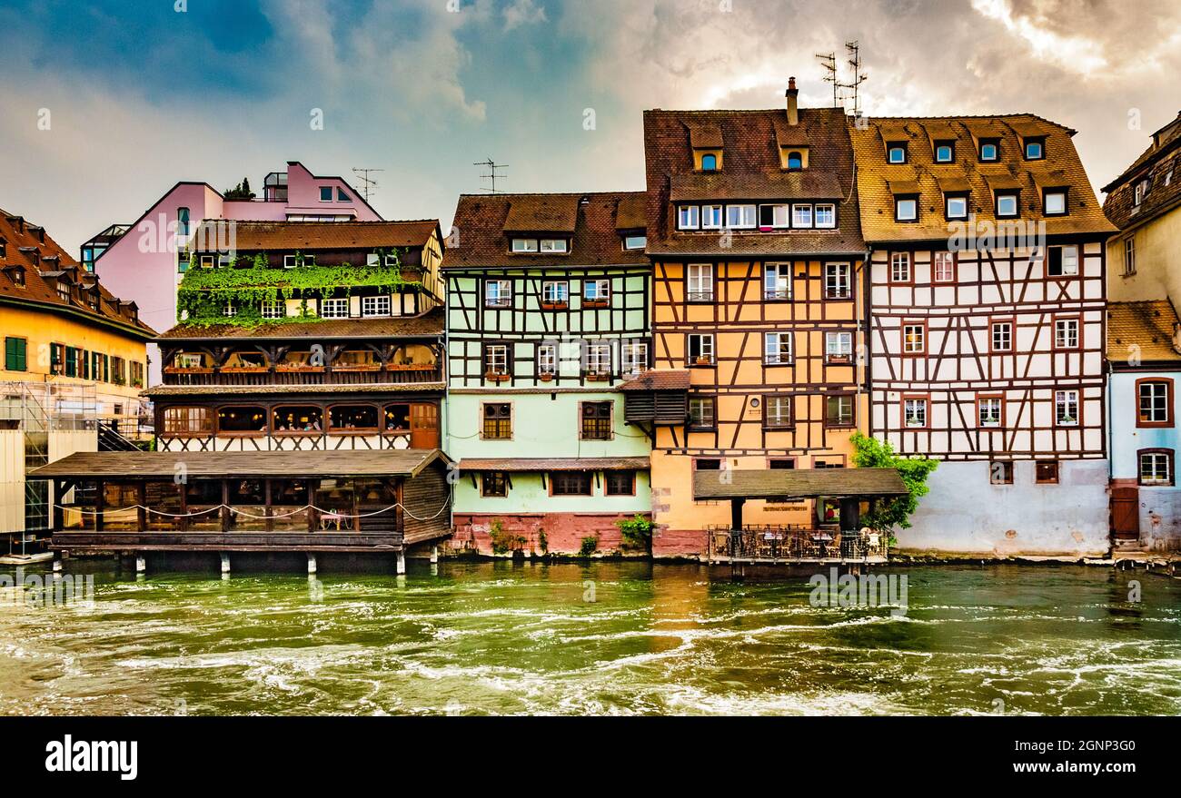 Gorgeous panoramic view of a row of lovely colourful half-timbered houses along the river Ill with dramatic clouds in the famous historical quarter... Stock Photo