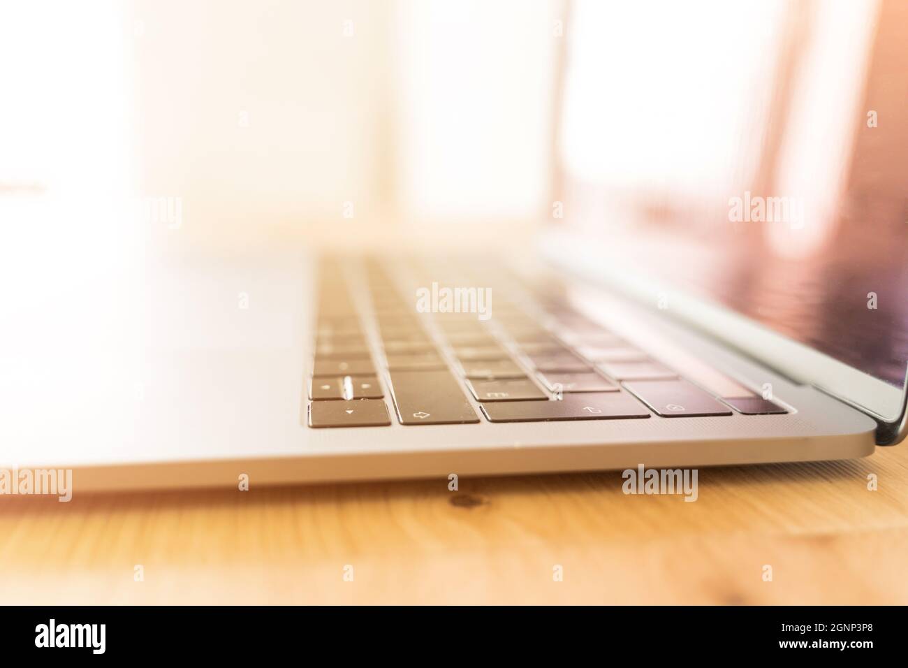 Modern laptop on a wooden table. Computer keyboard closeup Stock Photo